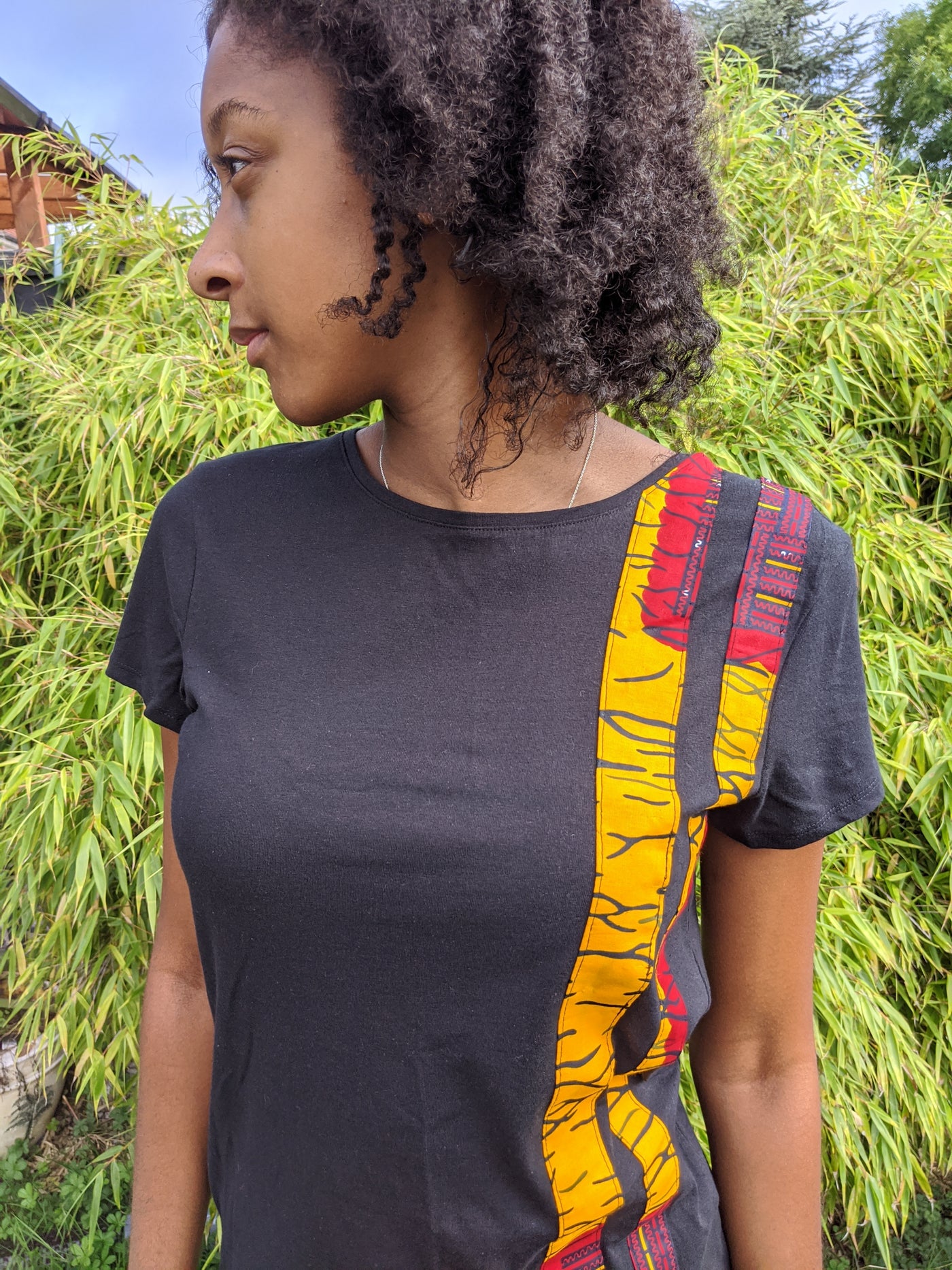 Black t-shirt with yellow and red Kente stripes
